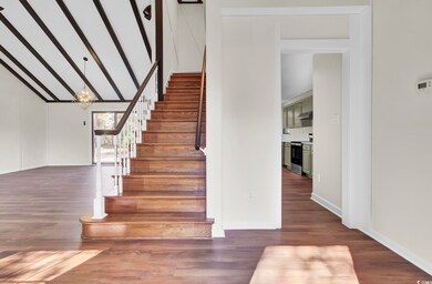 Stairs with an inviting chandelier, wood-type floo