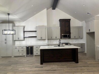 Kitchen with beverage cooler, open shelves, appliances with stainless steel finishes, light countertops, and backsplash