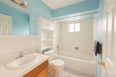 Full bathroom with vanity, shower / bathtub combination, light tile patterned floors, and tile walls