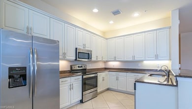 Kitchen with white cabinets, pendant lighting, kit