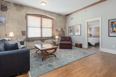 Living area with visible vents, wood finished floors, and baseboards