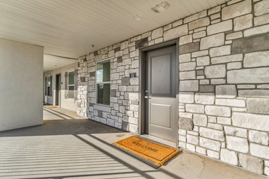Entrance to property featuring stone siding