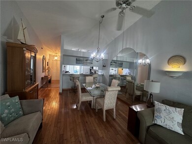 Dining space with a chandelier, hardwood / wood-style floors, ceiling fan, and arched walkways