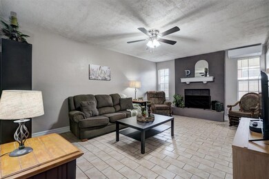 Living room with light tile floors, a textured cei