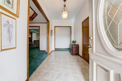 Foyer entrance with baseboards, light tile pattern