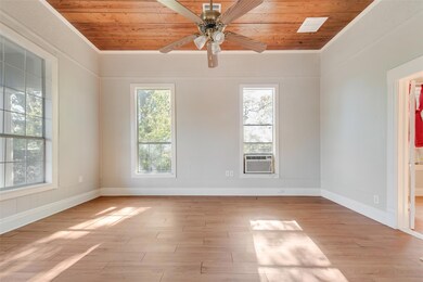 Empty room featuring cooling unit, wooden ceiling, ornamental molding, and light hardwood / wood-style flooring
