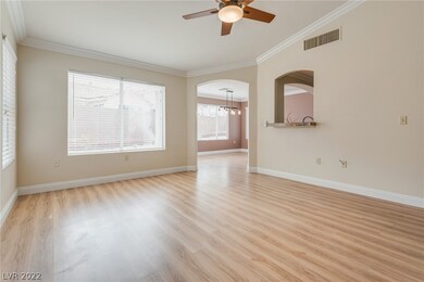 Nice Living room with crown moulding, ceiling fan,