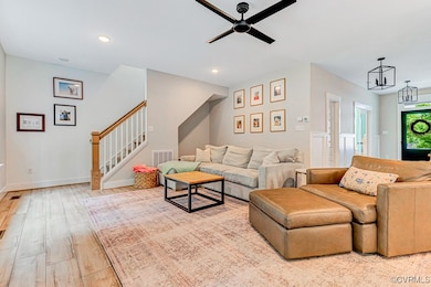 Living area with a ceiling fan, light wood-style f