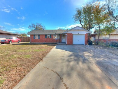 Single story home with a garage and a front lawn