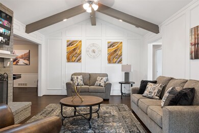 Living area featuring vaulted ceiling with beams, 