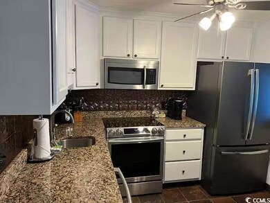 Kitchen featuring backsplash, white cabinets, sink
