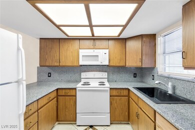 Kitchen featuring white appliances, backsplash, a