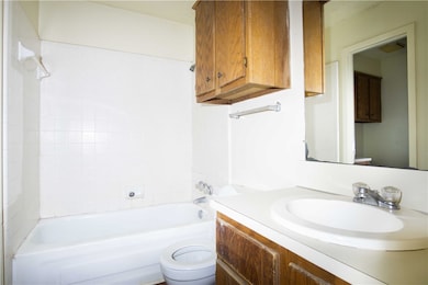 Bathroom featuring toilet, shower / washtub combin