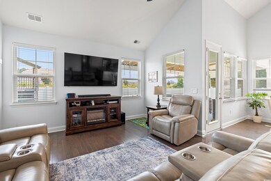 Living room featuring wood finished floors and high vaulted ceiling