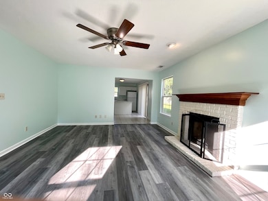 unfurnished living room featuring a fireplace, wood finished floors, and ceiling fan