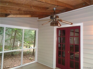 Screened in back porch with ceiling fan.