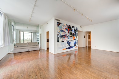 Another view of this spacious room features hardwood floors, large windows for natural light, and an open layout ideal for versatile living arrangements.