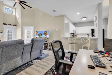 Living room with a towering ceiling, light hardwoo