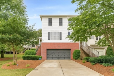 DIGITALLY MODIFIED COLOR of what unit could look like if painted white. View of front of home featuring brick siding, stairway, and an attached garage
