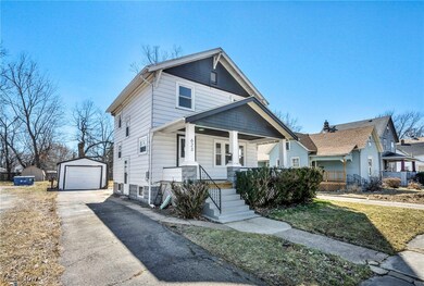 View of front of house featuring an outbuilding, a garage, covered porch, and driveway
