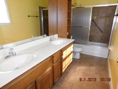 MASTER BATH WITH 2 SINK VANITY, CERAMIC TILE FLOOR AND TUB SURROUND. SLIDING  GLASS DOORS ON TUB