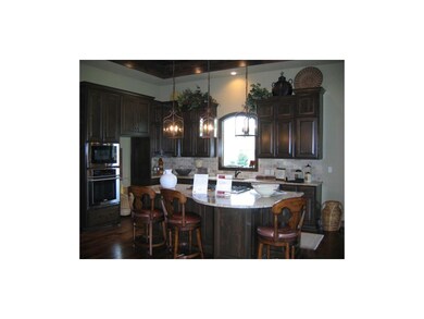 Kitchen area with piano shaped granite island & ga