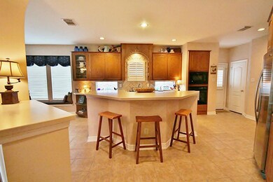 Large island kitchen with hard stone counter tops and custom built cabinets that are solid wood.