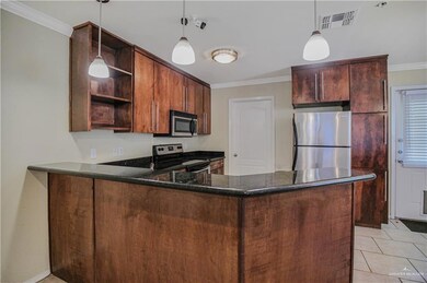Kitchen with appliances with stainless steel finishes, open shelves, a peninsula, ornamental molding, and pendant lighting