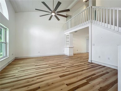 Unfurnished living room with high vaulted ceiling,