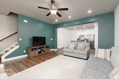 Living area with stairs, wood finished floors, a ceiling fan, recessed lighting, and a textured ceiling