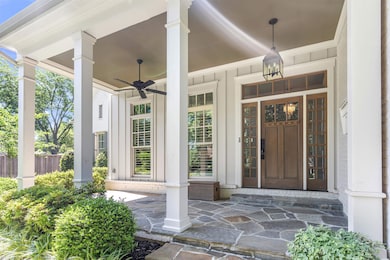 Doorway to property featuring ceiling fan and covered porch