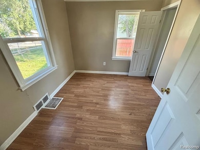 Empty room featuring wood finished floors and baseboards