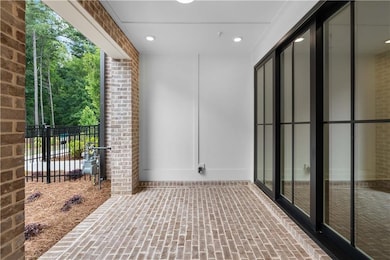 The covered brick patio with slider door is the perfect spot for entertaining.