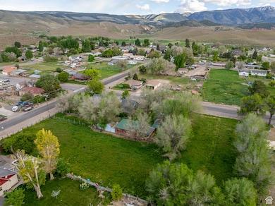 Aerial view of property and surrounding area with nearby suburban area and mountains
