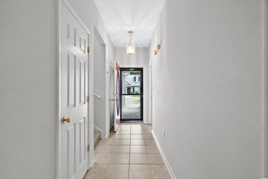 Hall with a textured ceiling and light tile patter