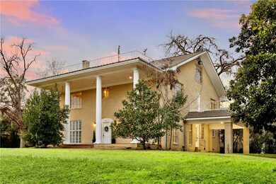 View of front of home with a balcony and a yard