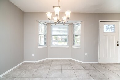 Enjoy a family meal or your morning cup of coffee in this peaceful dining area that's bathed in natural sunlight streaming in through the front facing bay window.  Also notice the stylish brushed nickel lighting, tile floors, and updated front door.