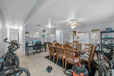 Dining area with ceiling fan, arched walkways, an office area, and dark aggregate flooring