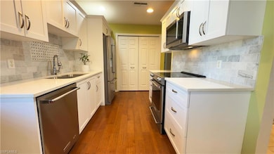 Kitchen with light quartz countertops, stainless s