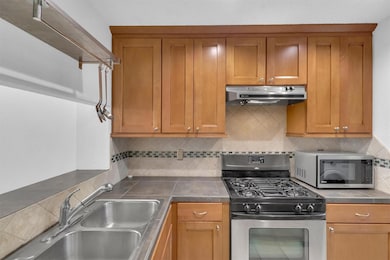 Kitchen with backsplash, a sink, stainless steel 