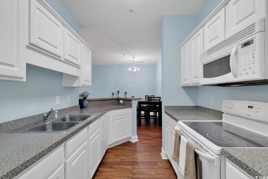 Kitchen with a notable chandelier, white cabinetry