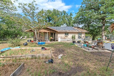 Back of property with a patio, a garden, and sola