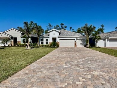 Ranch-style home featuring decorative driveway, a front lawn, and an attached garage