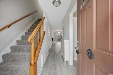 Foyer entrance with stairs, a ceiling fan, baseboards, visible vents, and light wood-style floors