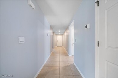 Hallway featuring baseboards, a barn door, and light tile patterned floors