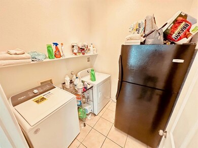 Clothes washing area with light tile patterned fl