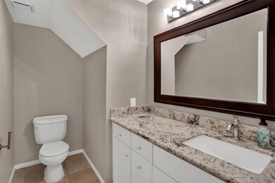 Powder bath with granite vanity just off the family room.