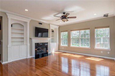Spacious family room features fireplace, crown and