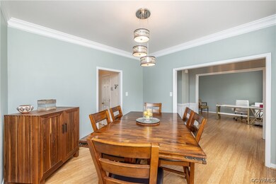 Dining area with crown molding and light bamboo fl