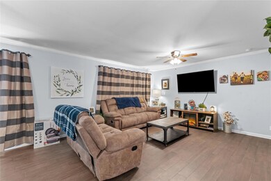 Living room with ceiling fan, ornamental molding, 